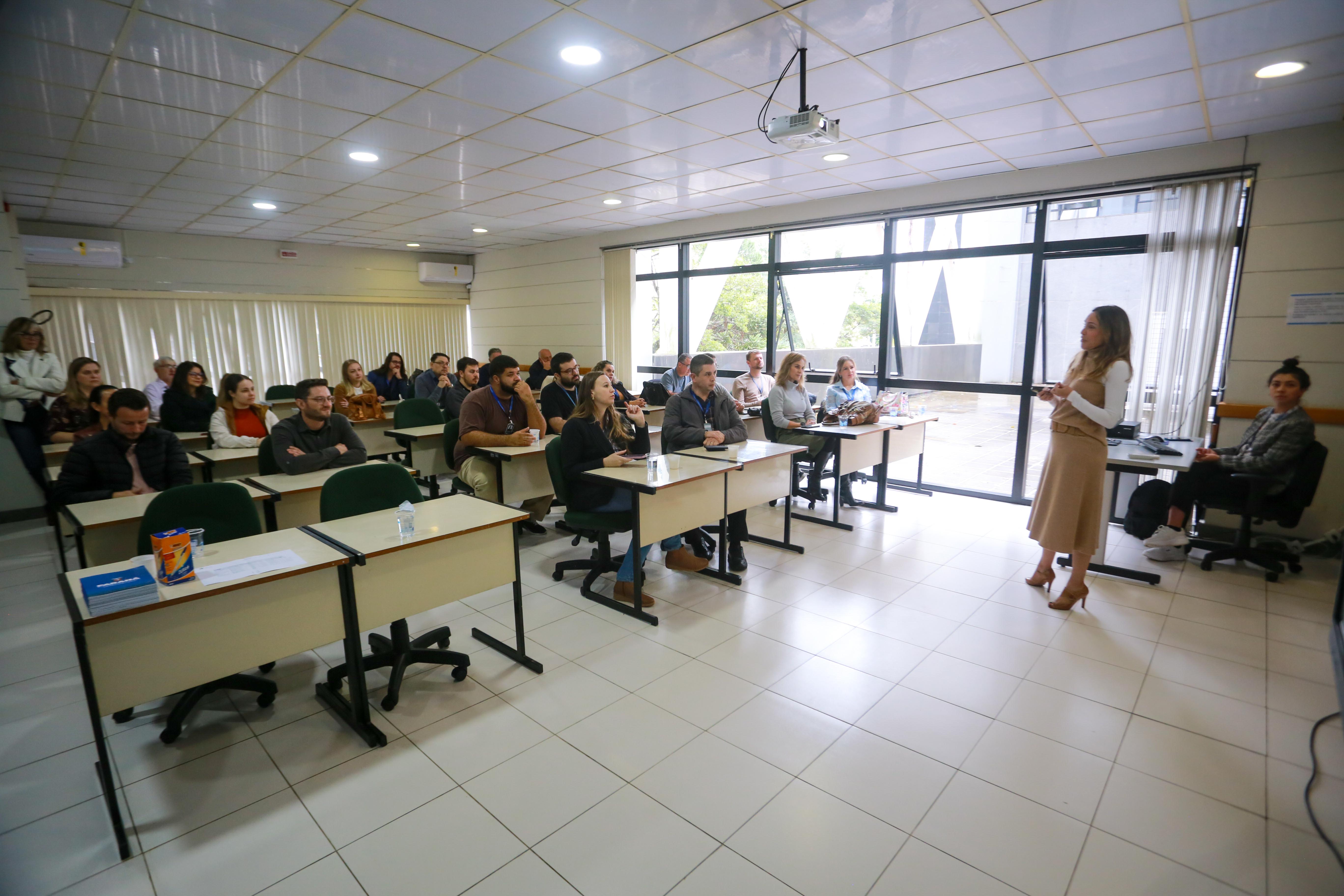 fotos do curso de integração em que aparecem os novos servidores e apresentações feitas por coordenadores e chefes de núcleos.