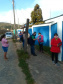 servidores entrevistam pessoas na fila para pegar kit merenda escolar