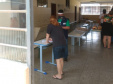 servidores entrevistam pessoas na fila para pegar kit merenda escolar