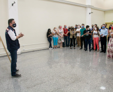 servidores reunidos na frente da sala com paredes de vidro