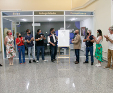 servidores reunidos na frente da sala com paredes de vidro