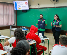 equipes distribuem formulários a alunos em pesquisa