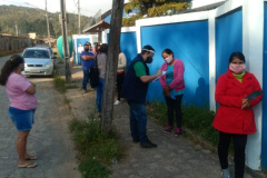 servidores entrevistam pessoas na fila para pegar kit merenda escolar