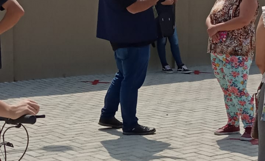 servidores entrevistam pessoas na fila para receber o kit merenda escolar