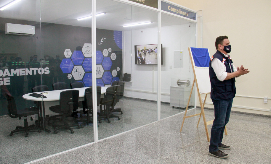 servidores reunidos na frente da sala com paredes de vidro