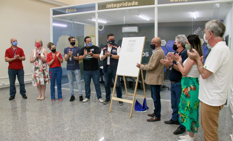 servidores reunidos na frente da sala com paredes de vidro