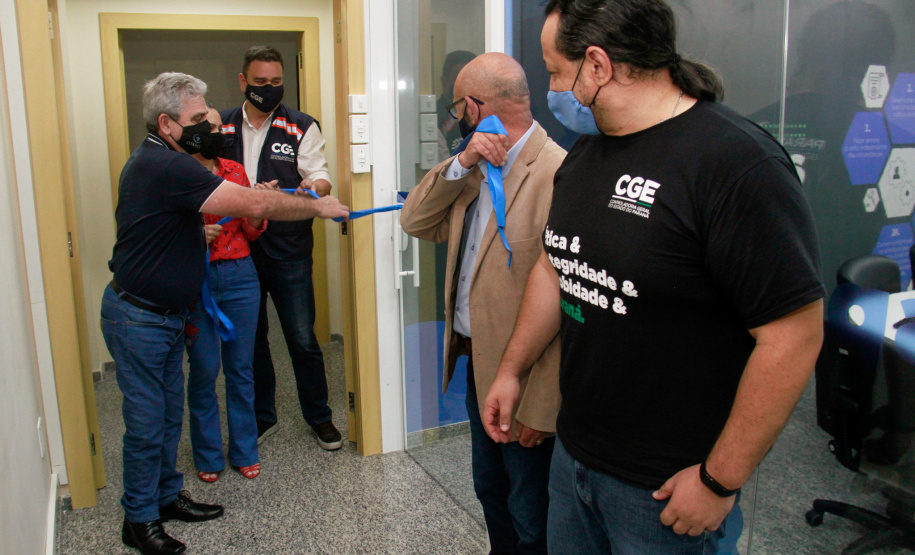 servidores reunidos na frente da sala com paredes de vidro