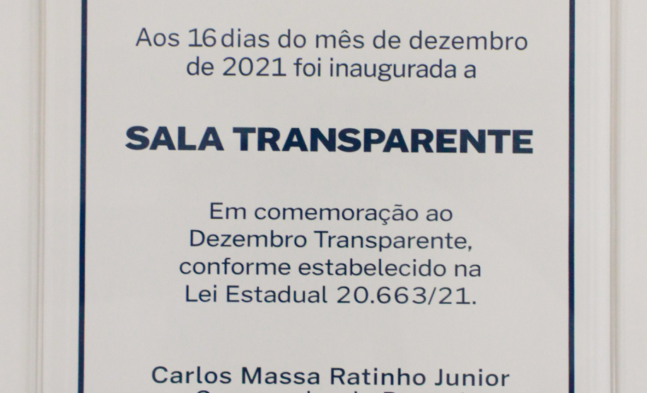 servidores reunidos na frente da sala com paredes de vidro