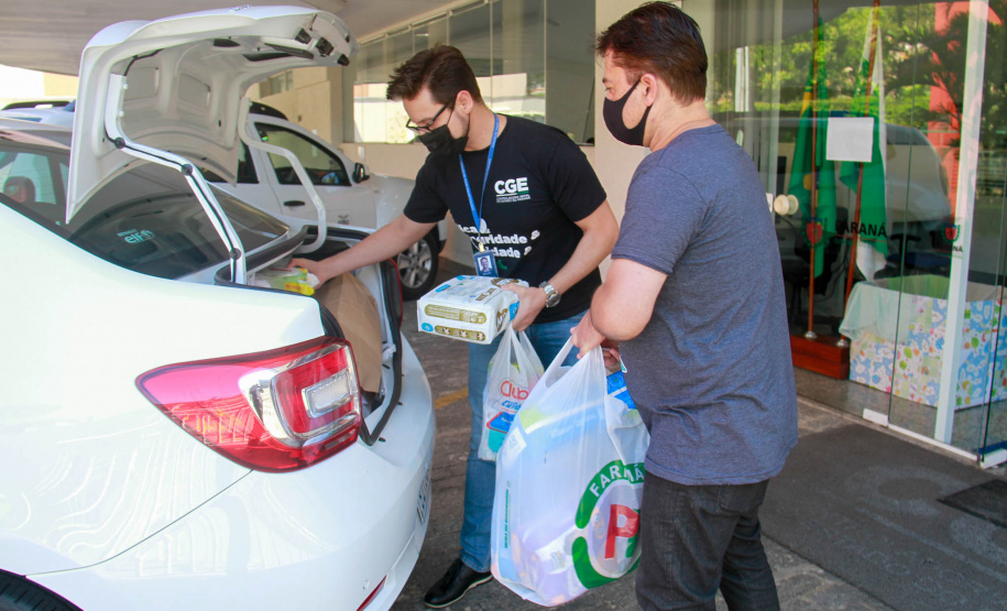 servidores carregam carro com donativos