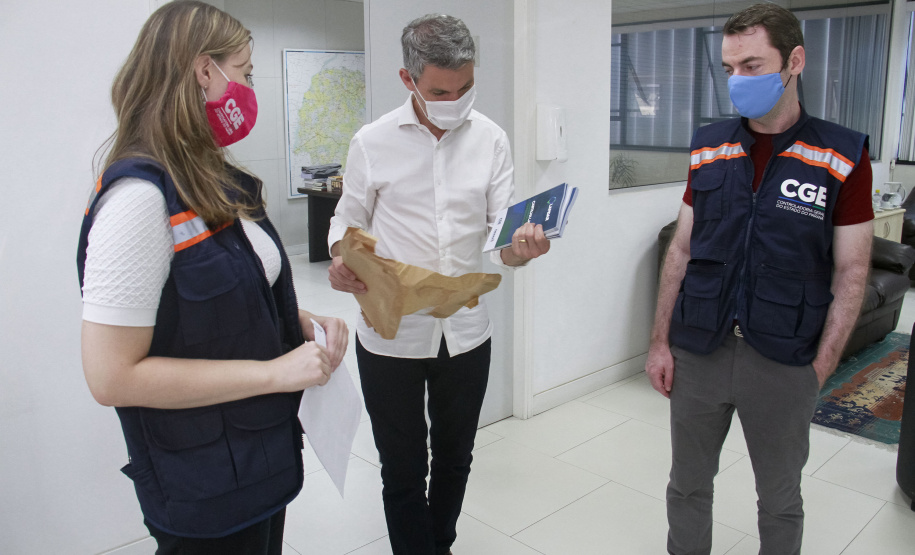 equipe enrega cartilhas físicas a representantes de órgãos do governo.