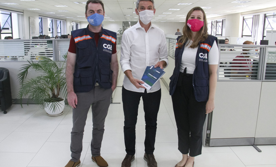 equipe enrega cartilhas físicas a representantes de órgãos do governo.