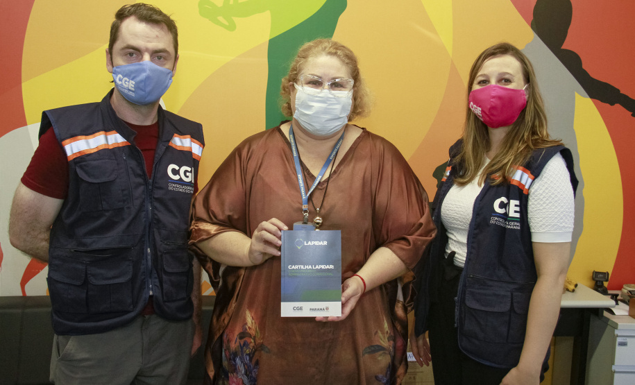 equipe enrega cartilhas físicas a representantes de órgãos do governo.