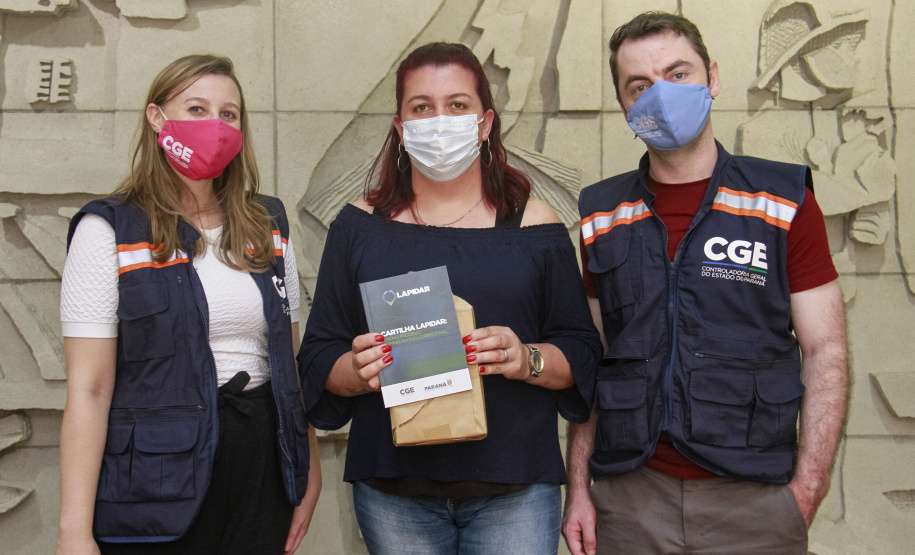 equipe enrega cartilhas físicas a representantes de órgãos do governo.