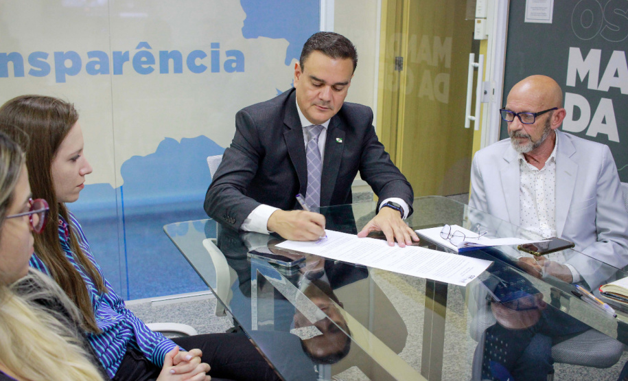 Controlador-Geral assina resolução na presença de servidores da CGE e na tela representantes da UNOPS