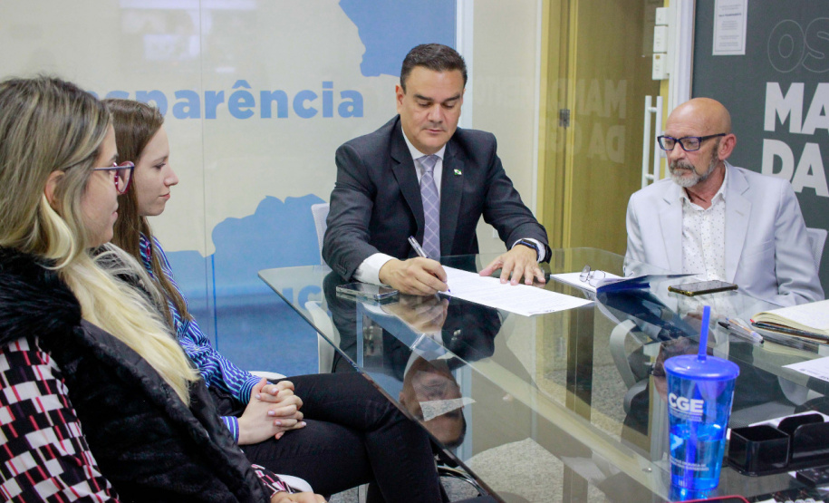 Controlador-Geral assina resolução na presença de servidores da CGE e na tela representantes da UNOPS