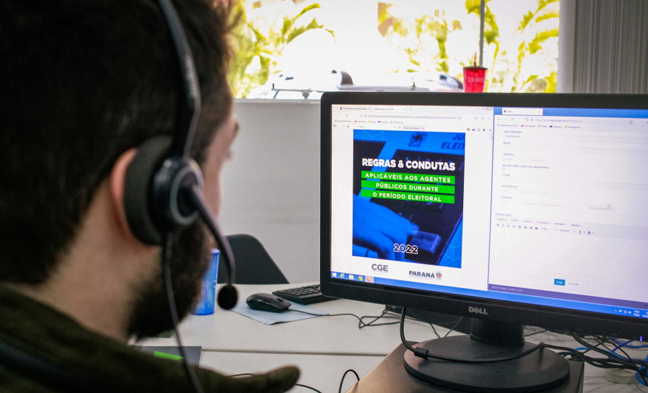 servdor olha tela em que está a capa da cartilha