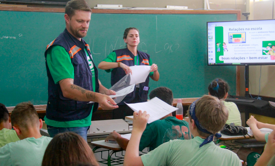 equipes distribuem formulários a alunos em pesquisa