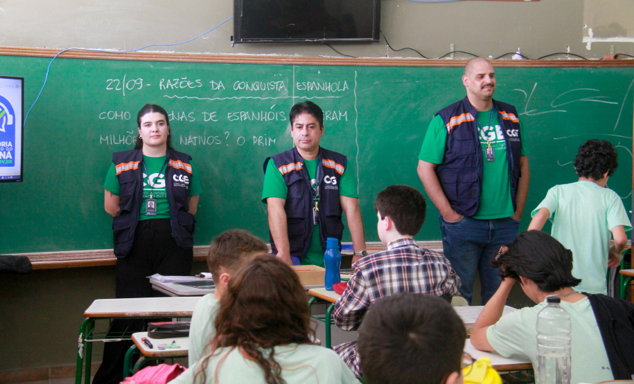 equipes distribuem formulários a alunos em pesquisa