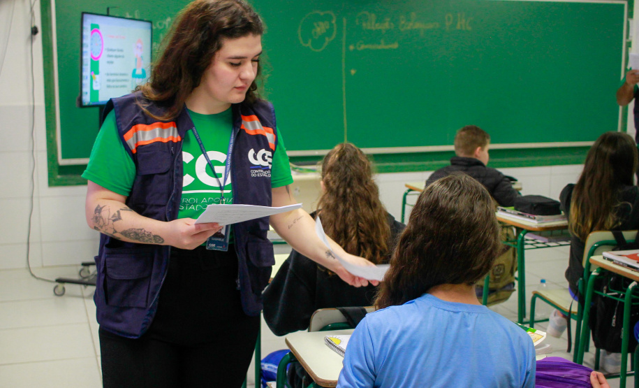 equipes distribuem formulários a alunos em pesquisa