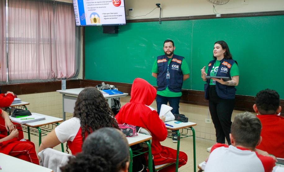 equipes distribuem formulários a alunos em pesquisa